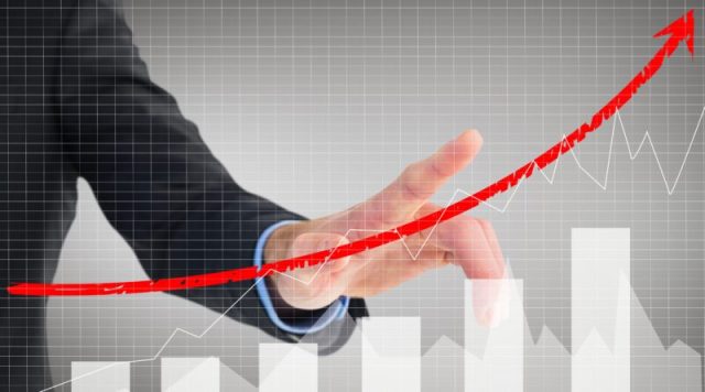 composite of businessman pointing at rising graph