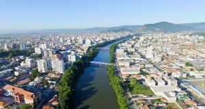FAHECE abre inscrições urgentes para assistente administrativo em Tubarão — prazo encerra amanhã Vista aérea de Tubarão SC, com o rio cortando a área urbana ao entardecer
