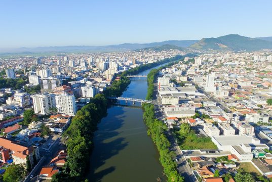 FAHECE abre inscrições urgentes para assistente administrativo em Tubarão — prazo encerra amanhã Vista aérea de Tubarão SC, com o rio cortando a área urbana ao entardecer